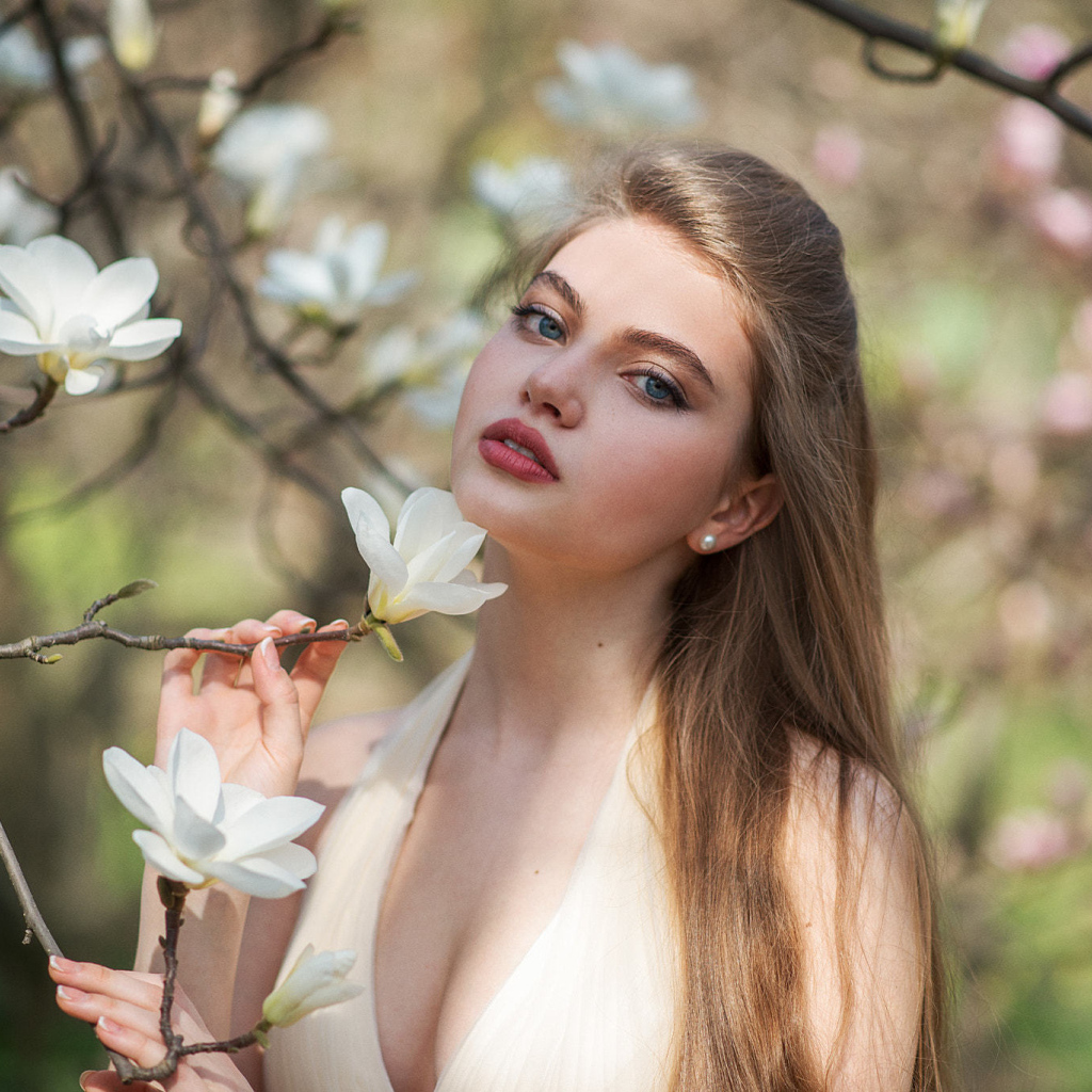 Красивая девушка с белыми цветами магнолии
