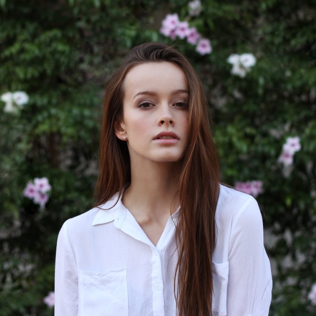 Красивая длинноволосая девушка в белой рубашке