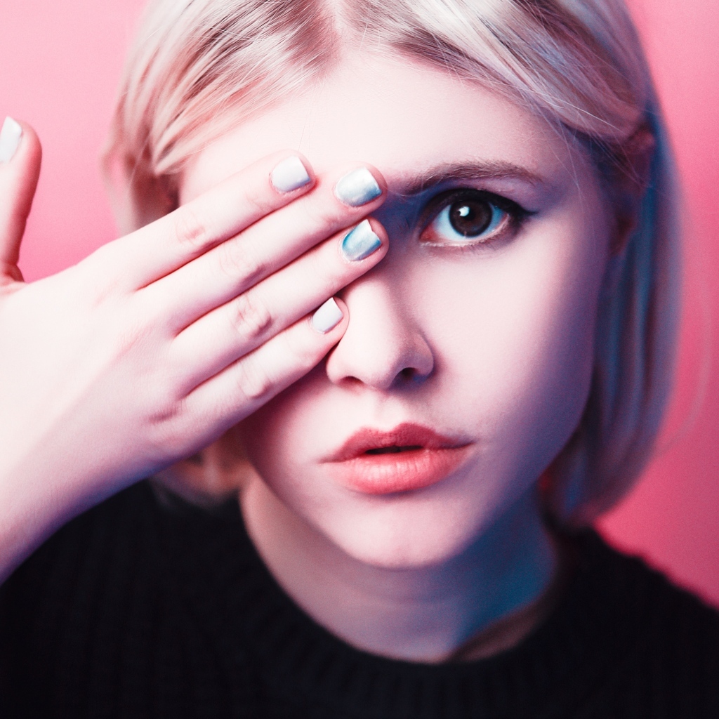 Кареглазая девушка закрыла глаз рукой