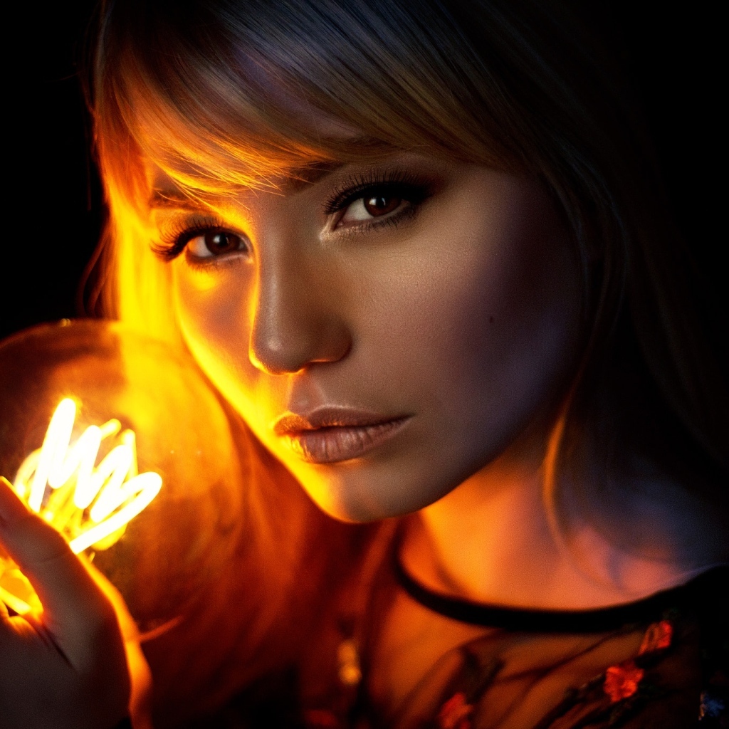 Кареглазая девушка с лампочкой в руках