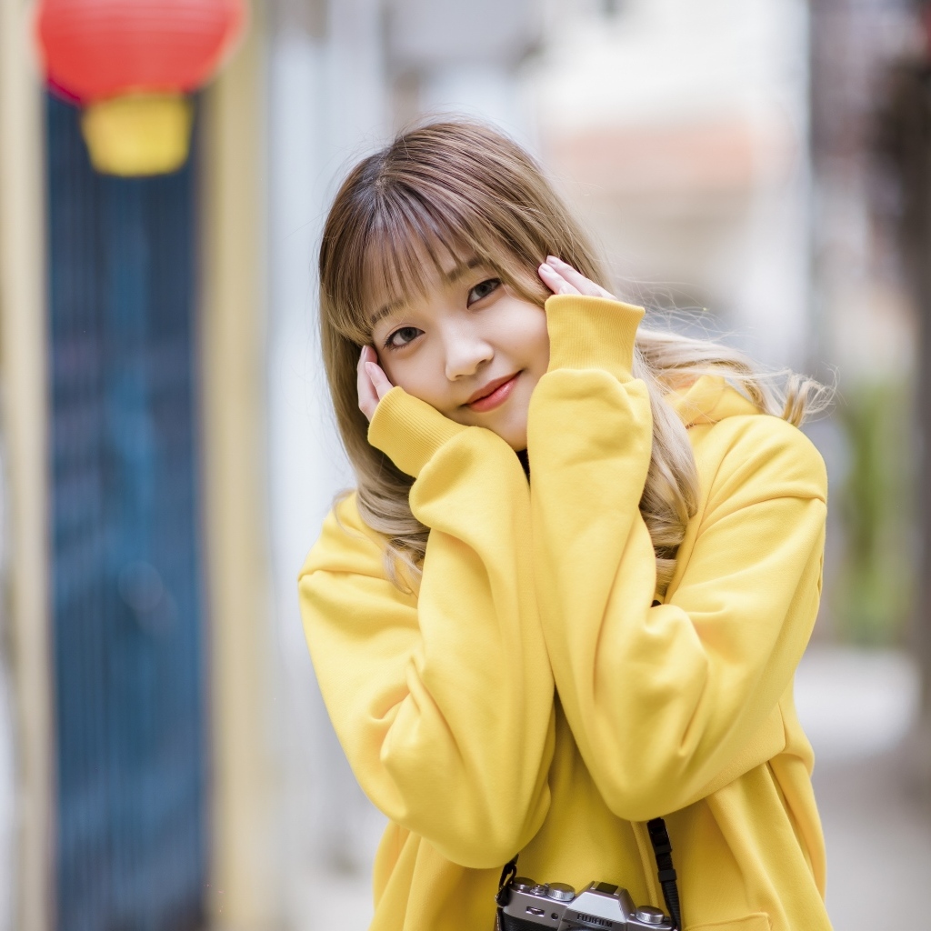 Милая девушка азиатка в желтом свитере