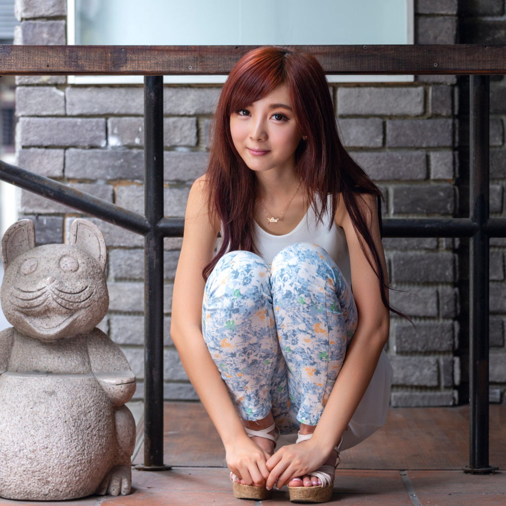 Милая девушка азиатка позирует со статуэткой