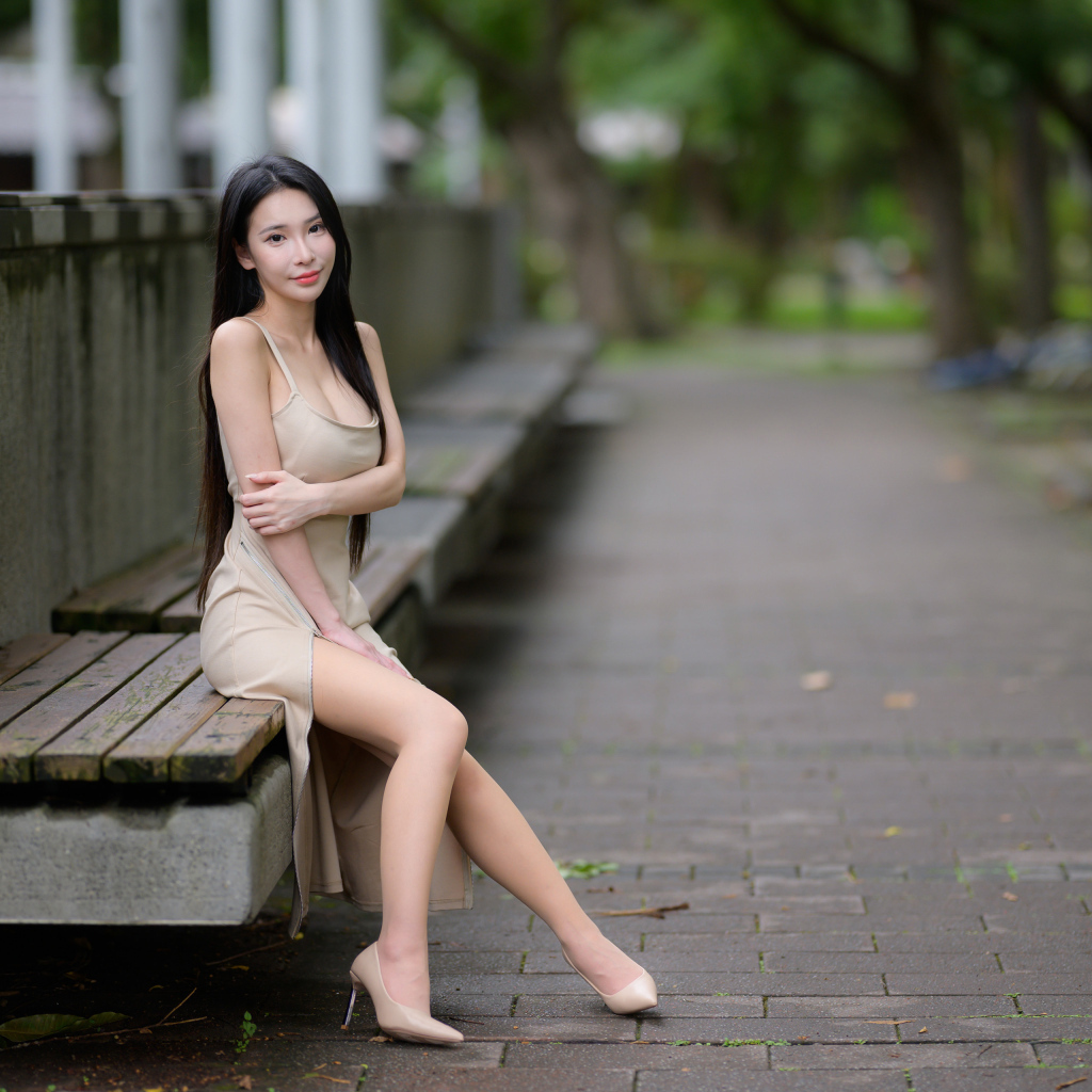 Милая девушка азиатка сидит на лавке