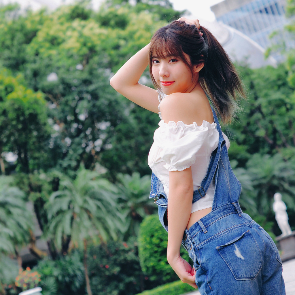 Милая девушка азиатка в джинсовом комбинезоне