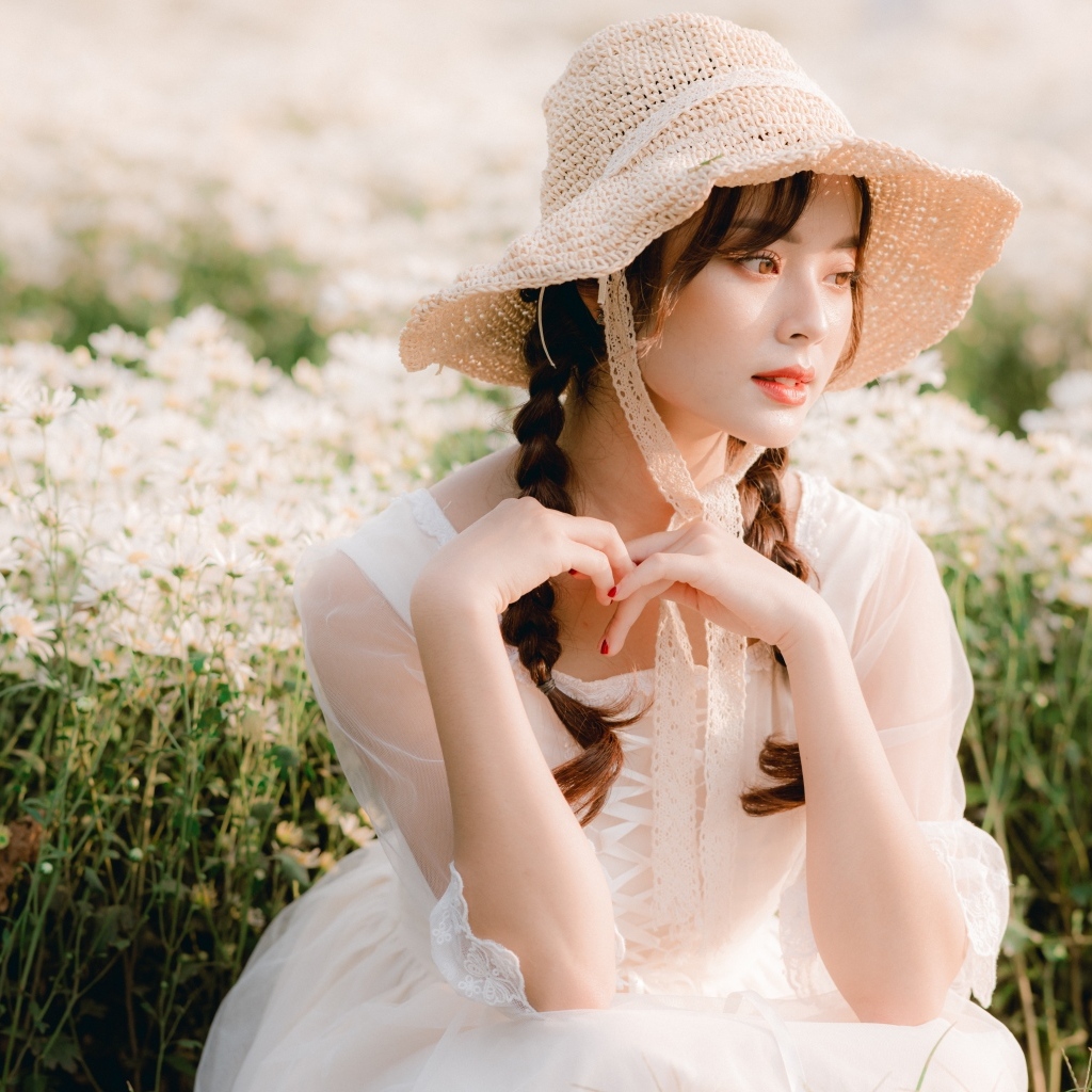 Милая азиатка в шляпе и белом платье 