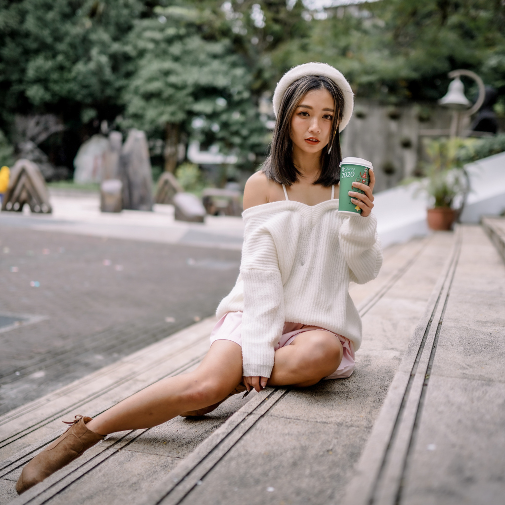 Милая азиатка в с кофе в руках 