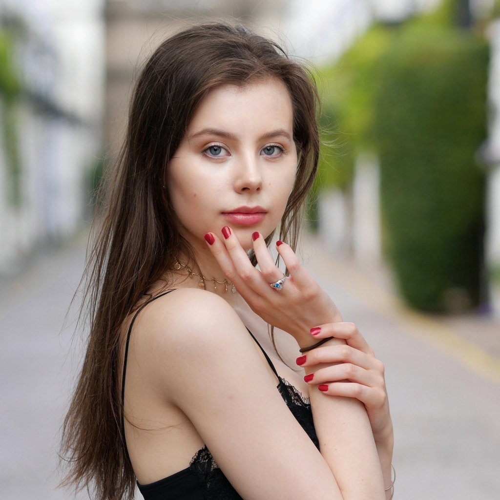 Милая голубоглазая девушка с красным маникюром