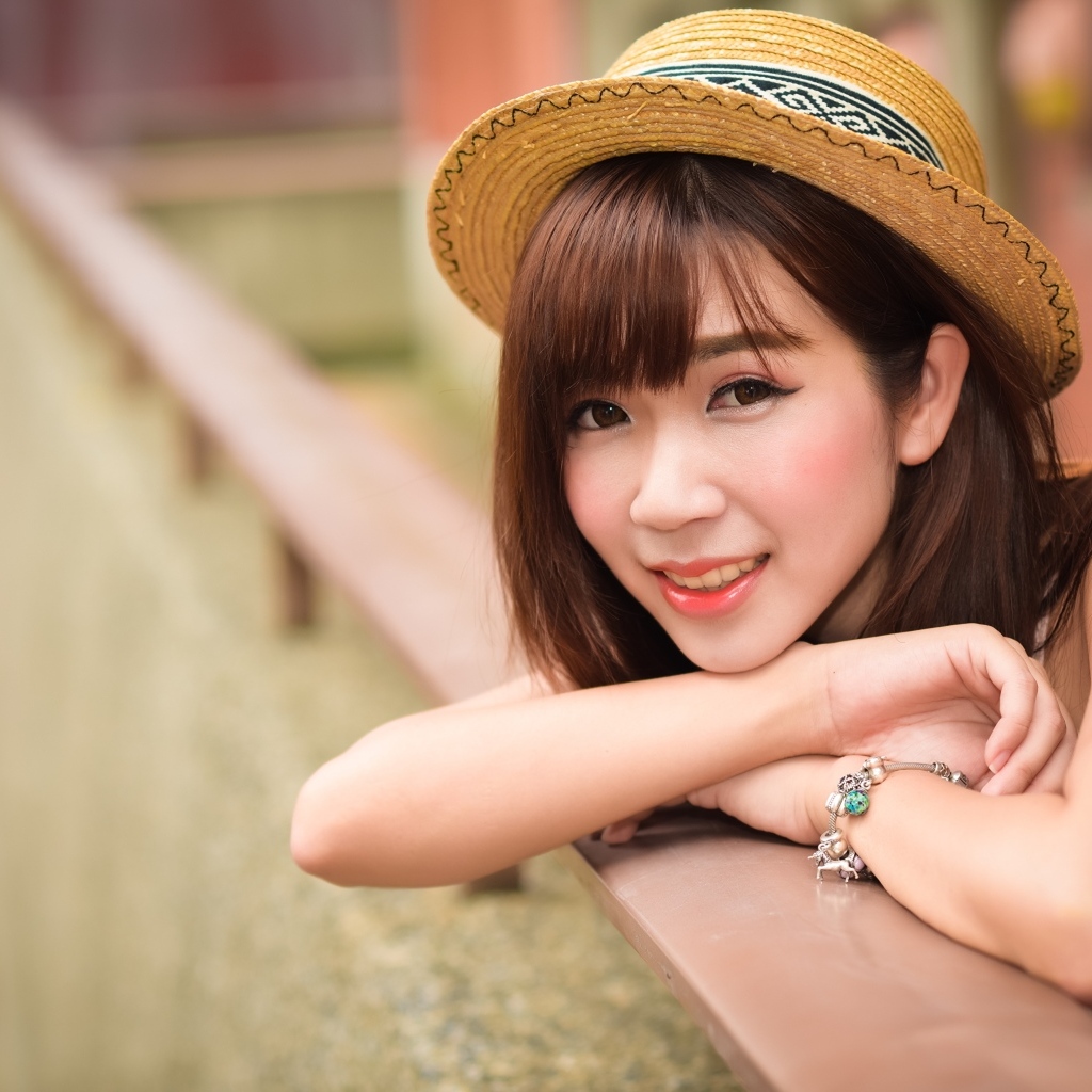 Милая улыбка азиатки в соломенной шляпе 