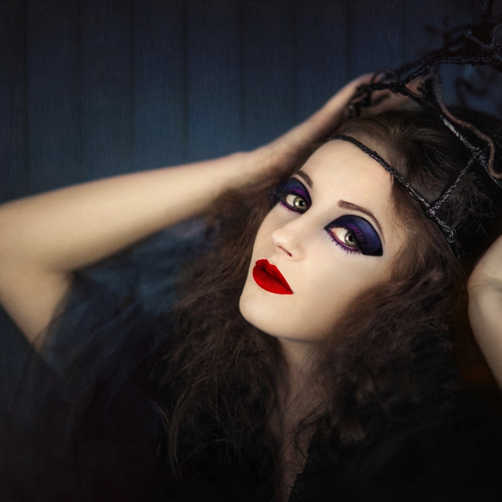 Девушка в черном наряде с ярким макияжем