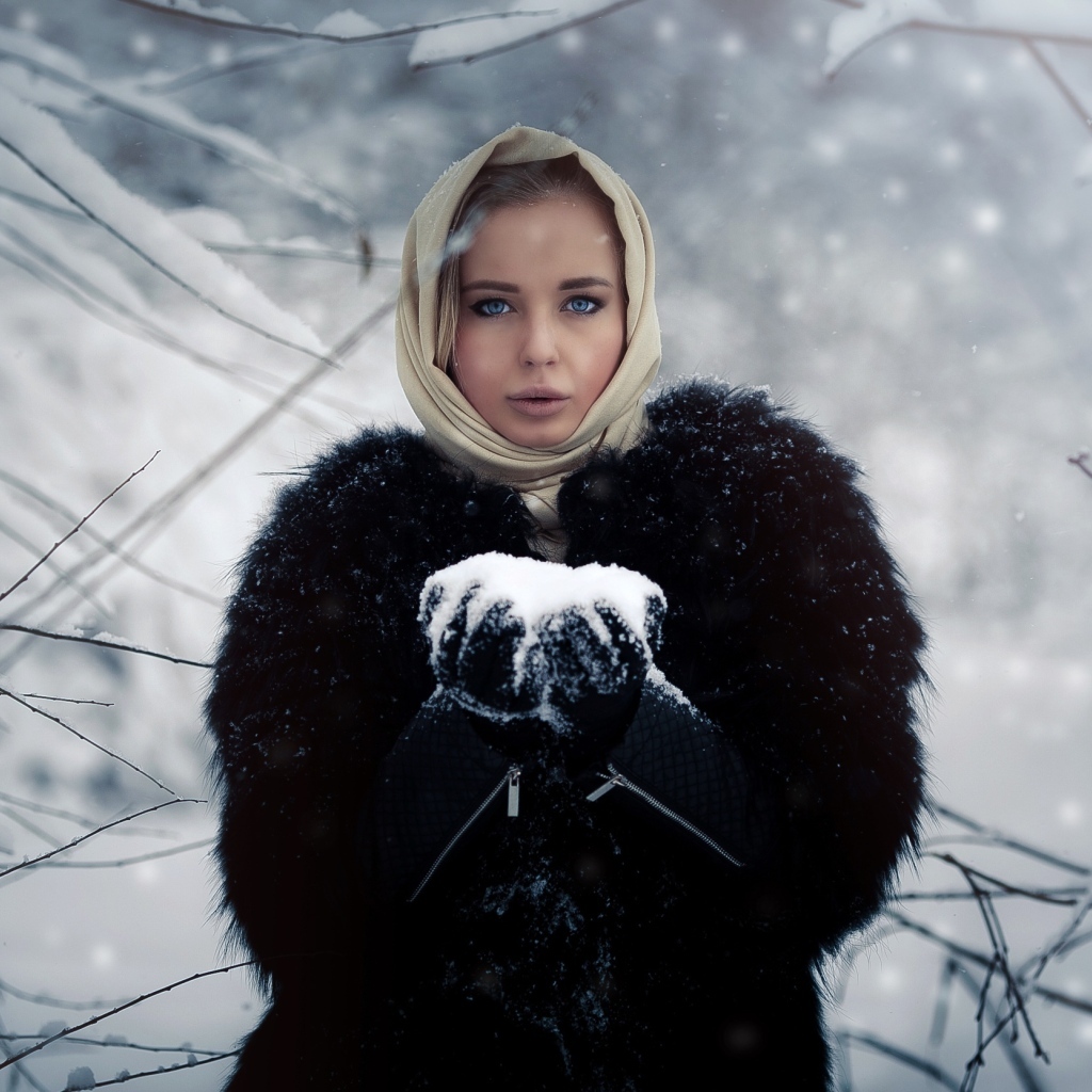 Девушка в черной шубе в заснеженном лесу