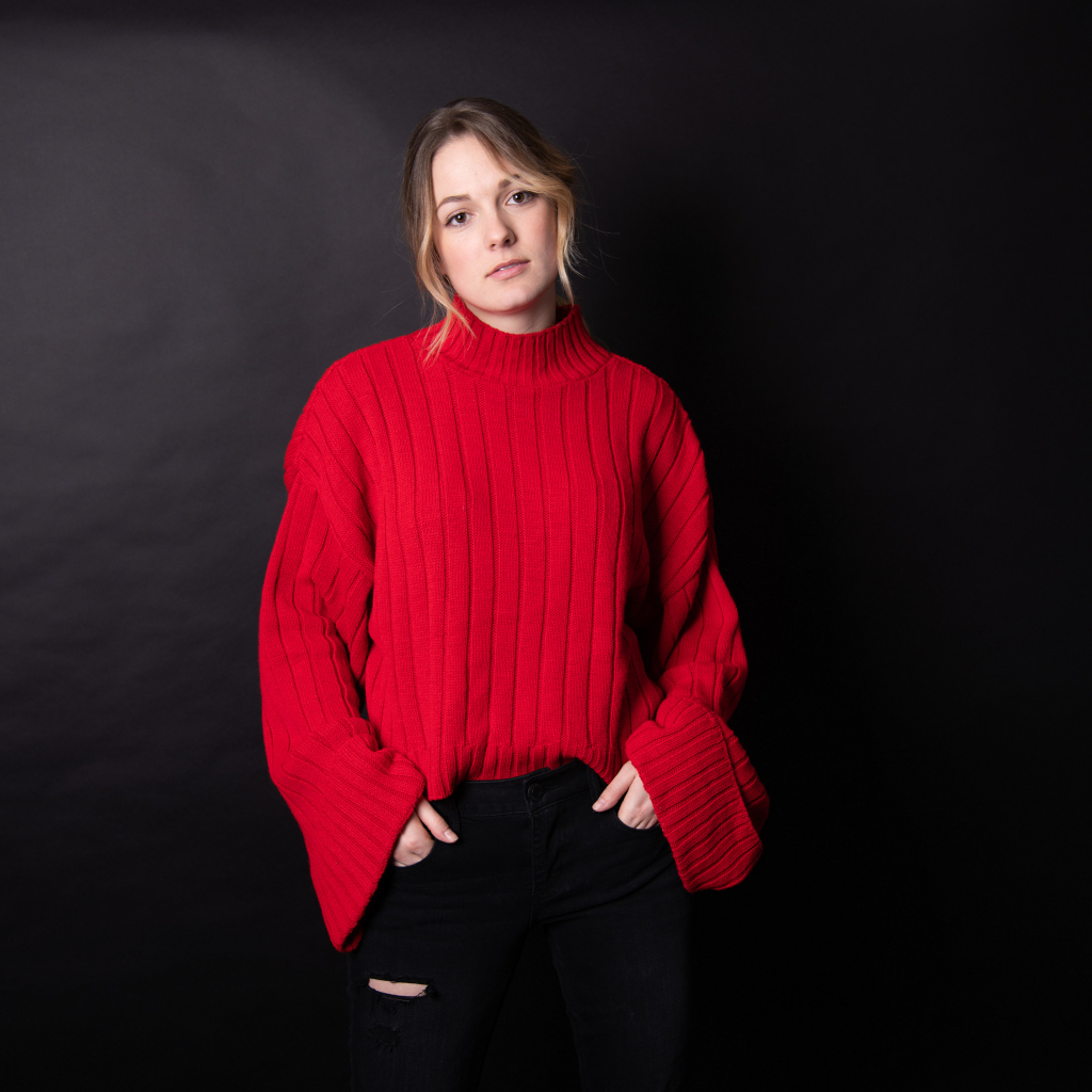 Девушка в красном свитере на черном фоне