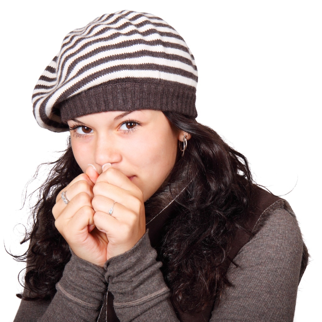 Девушка в теплой полосатой шапке на белом фоне