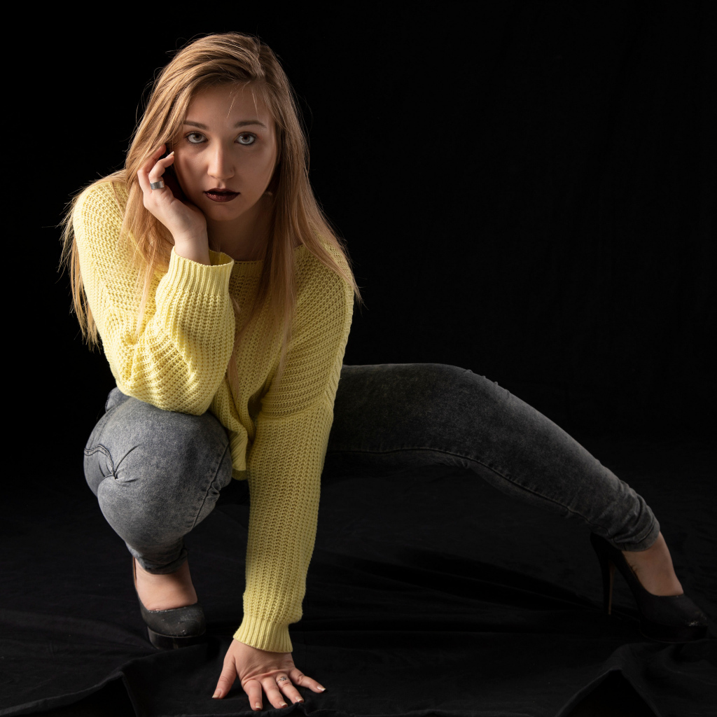 Девушка в желтом свитере на черном фоне