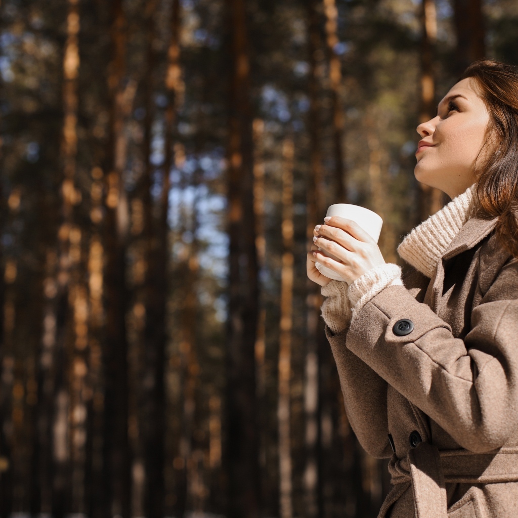 Девушка с чашкой кофе в парке