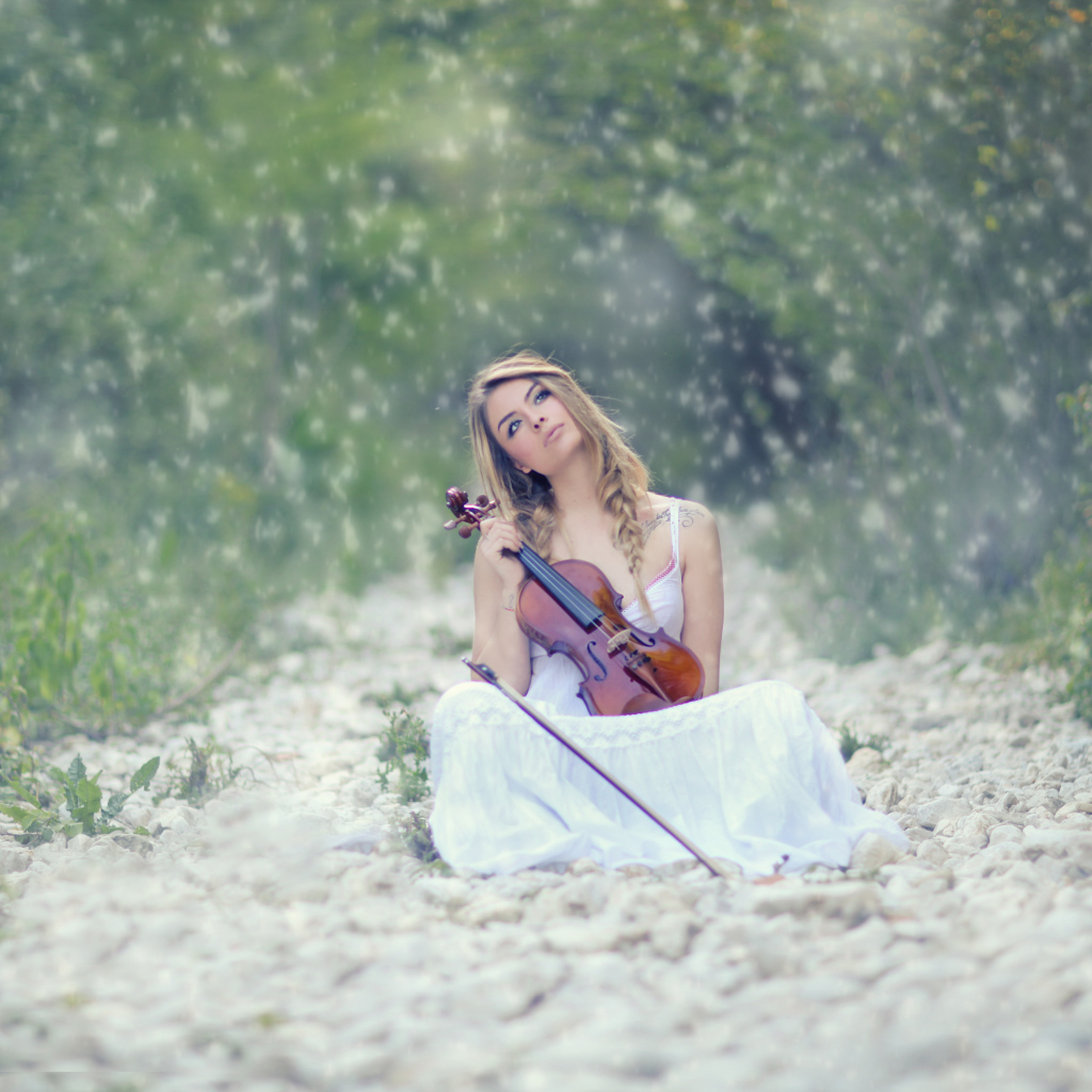 Девушка со скрипкой в руках в лесу