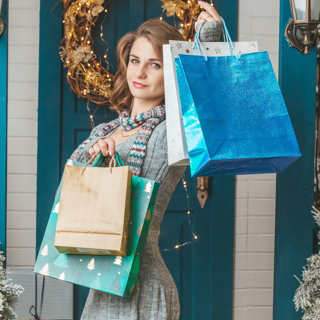 Девушка с пакетами стоит у двери