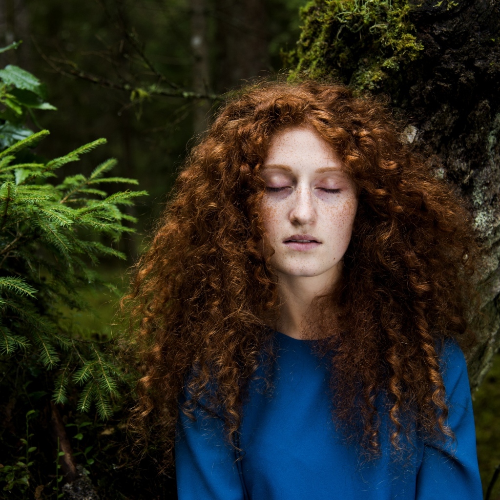 Девушка с кудрявыми волосами в лесу