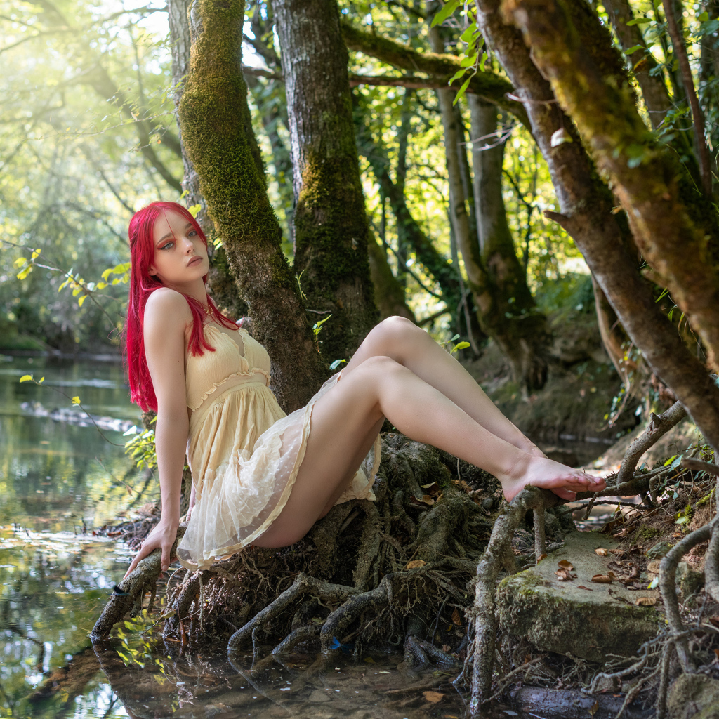 Девушка с розовыми волосами у пруда в лесу