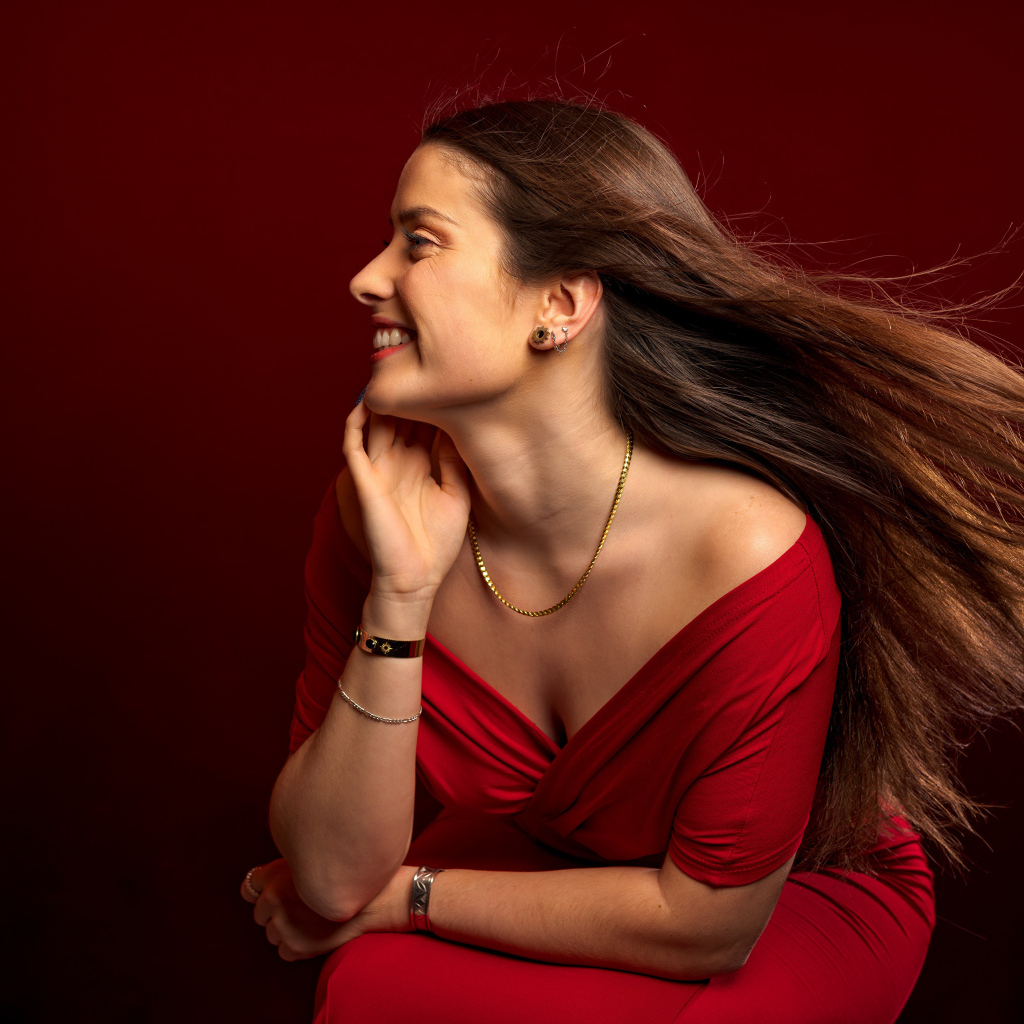 Длинные волосы у красивой девушки в красном платье