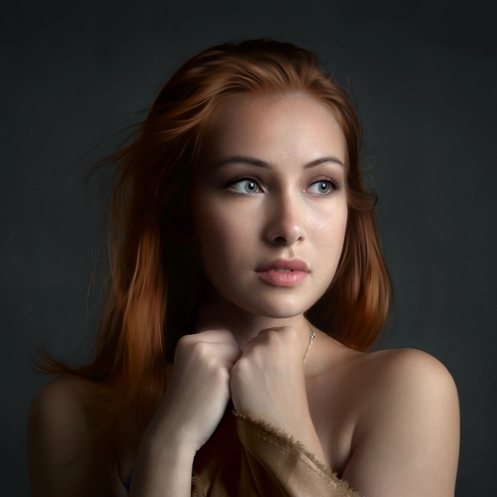 Рыжеволосая девушка с красивыми серыми глазами на сером фоне