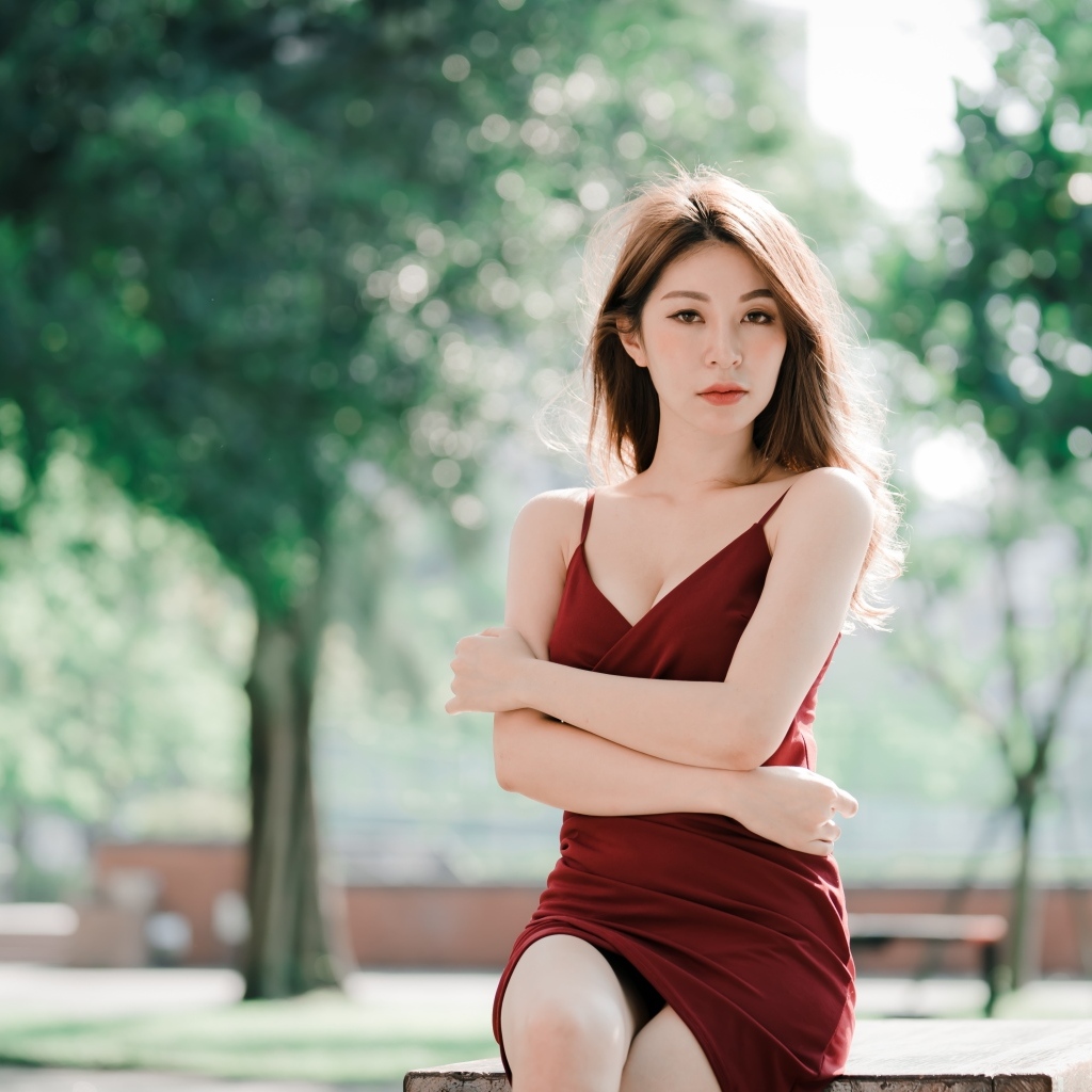 Серьезная девушка азиатка в красном платье