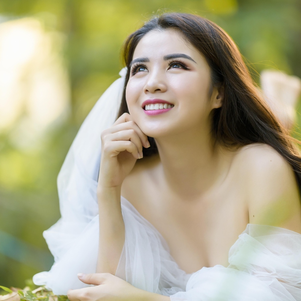 Улыбающаяся девушка азиатка в платье невесты