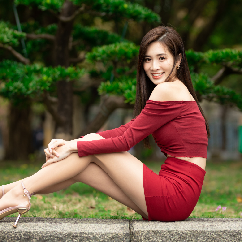 Улыбающаяся азиатка в красном костюме