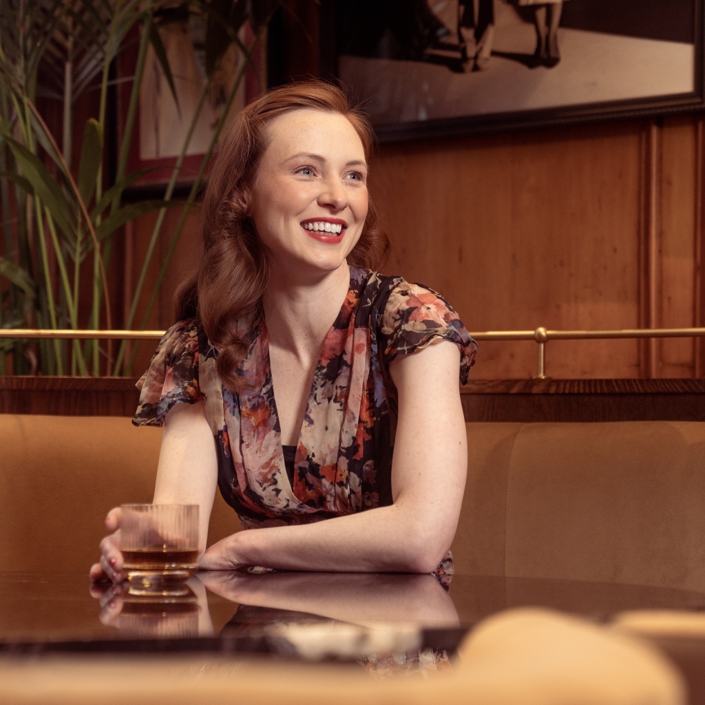Улыбающаяся девушка за столиком в кафе