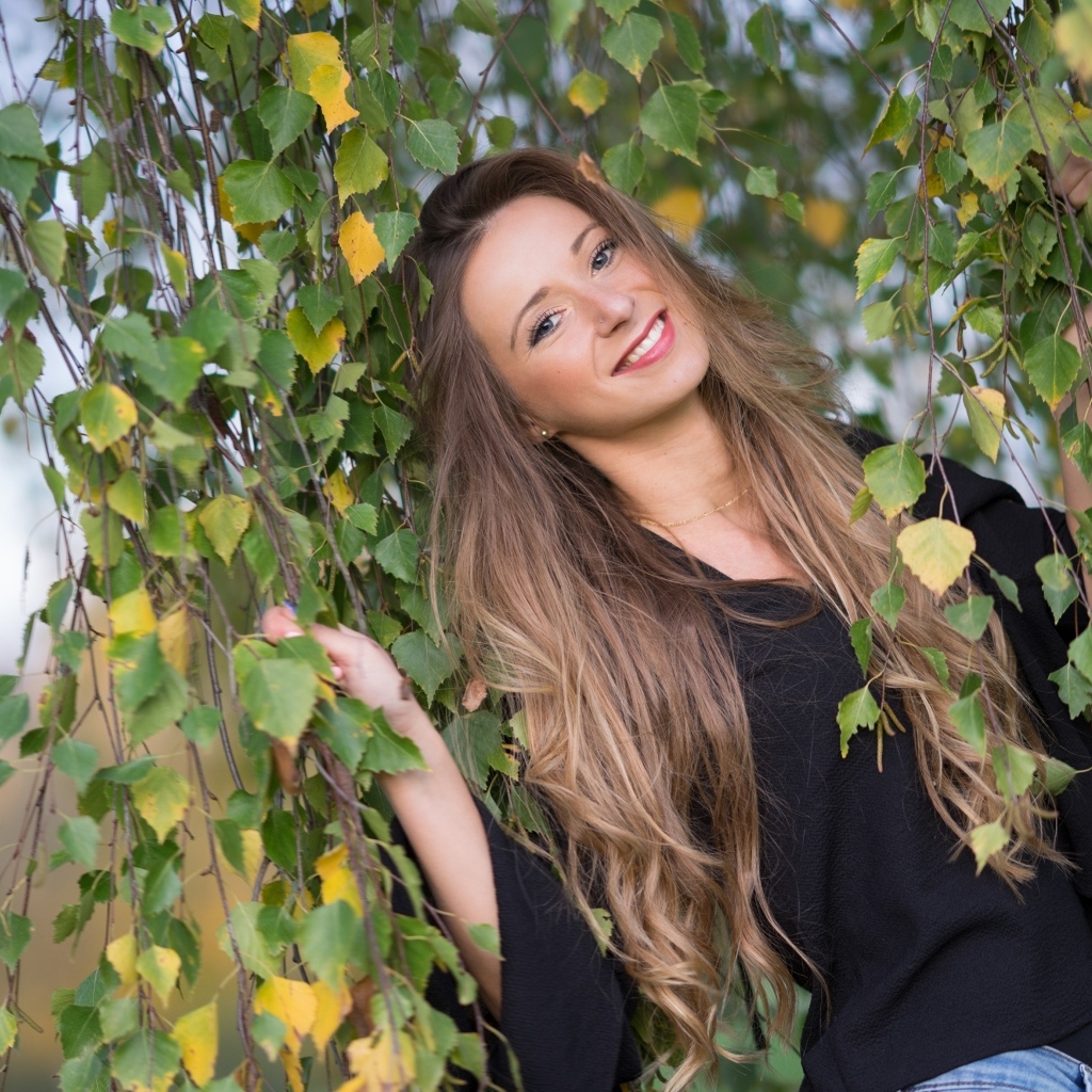 Улыбающаяся девушка в ветках березы