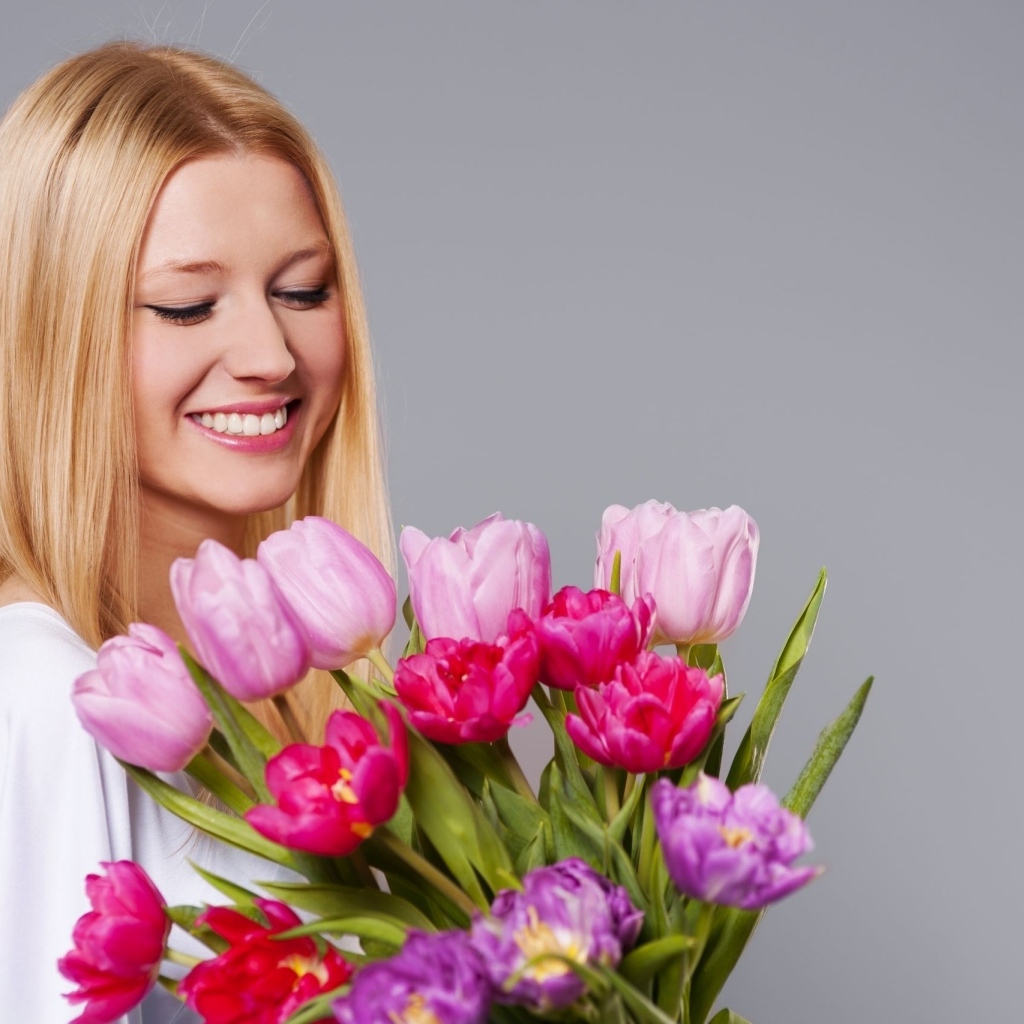 Улыбающаяся девушка с букетом тюльпанов
