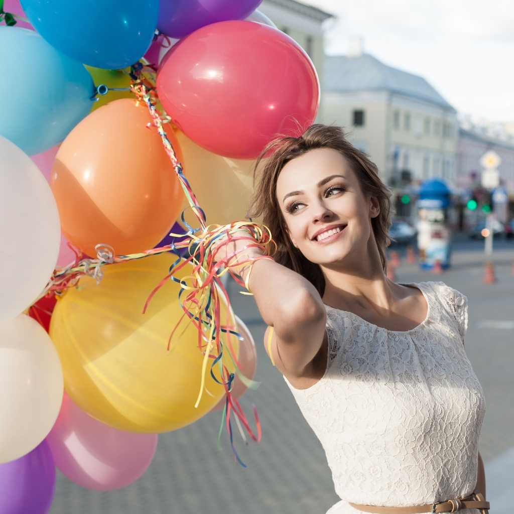 Улыбающаяся девушка с воздушными шариками