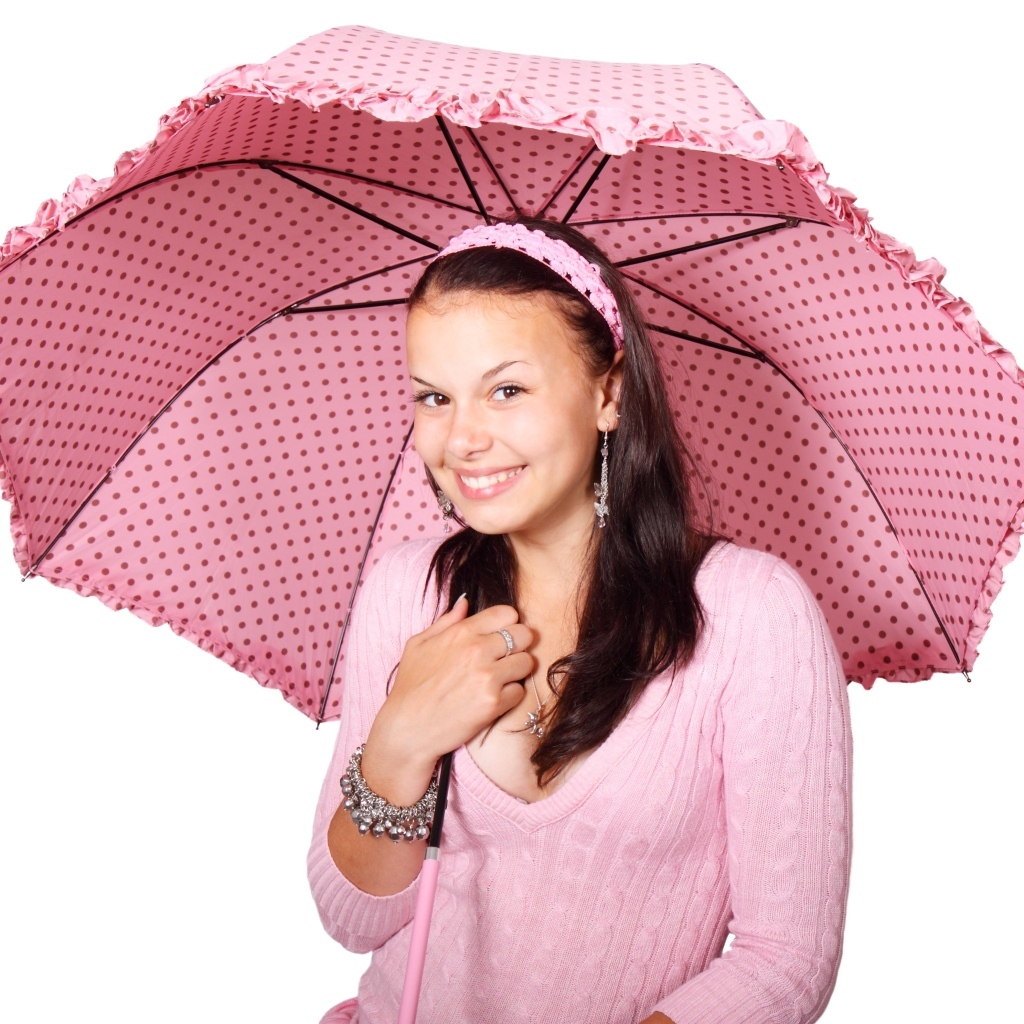 Улыбающаяся девушка с розовым зонтом на белом фоне