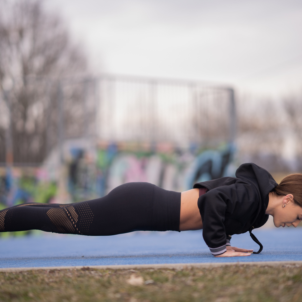 Спортивная девушка отжимается от земли