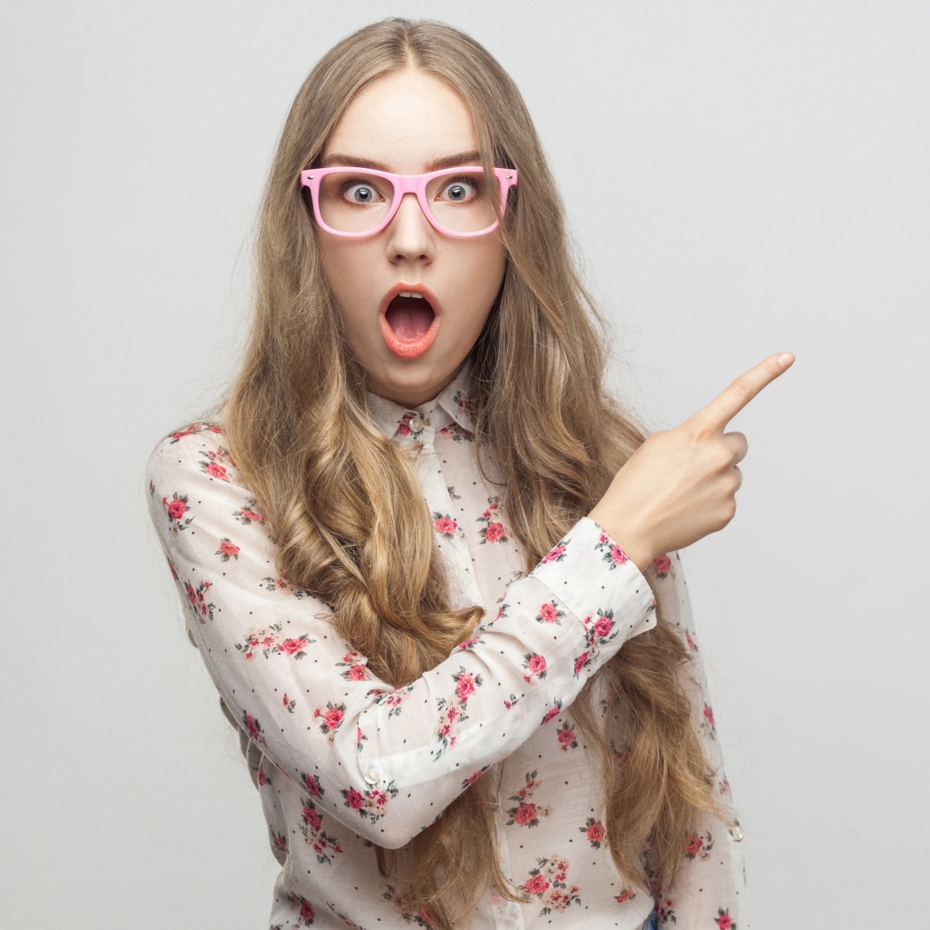 Удивленная девушка на сером фоне