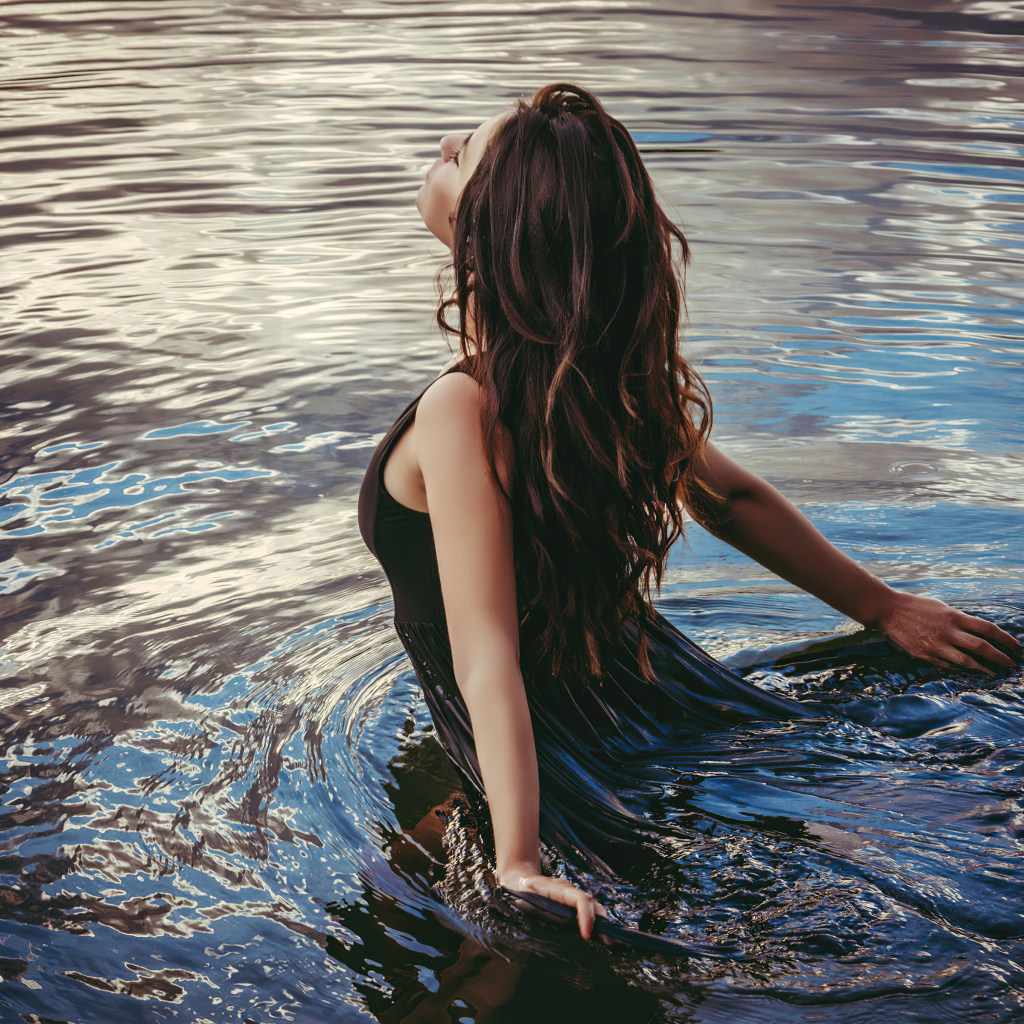 Молодая девушка купается в воде