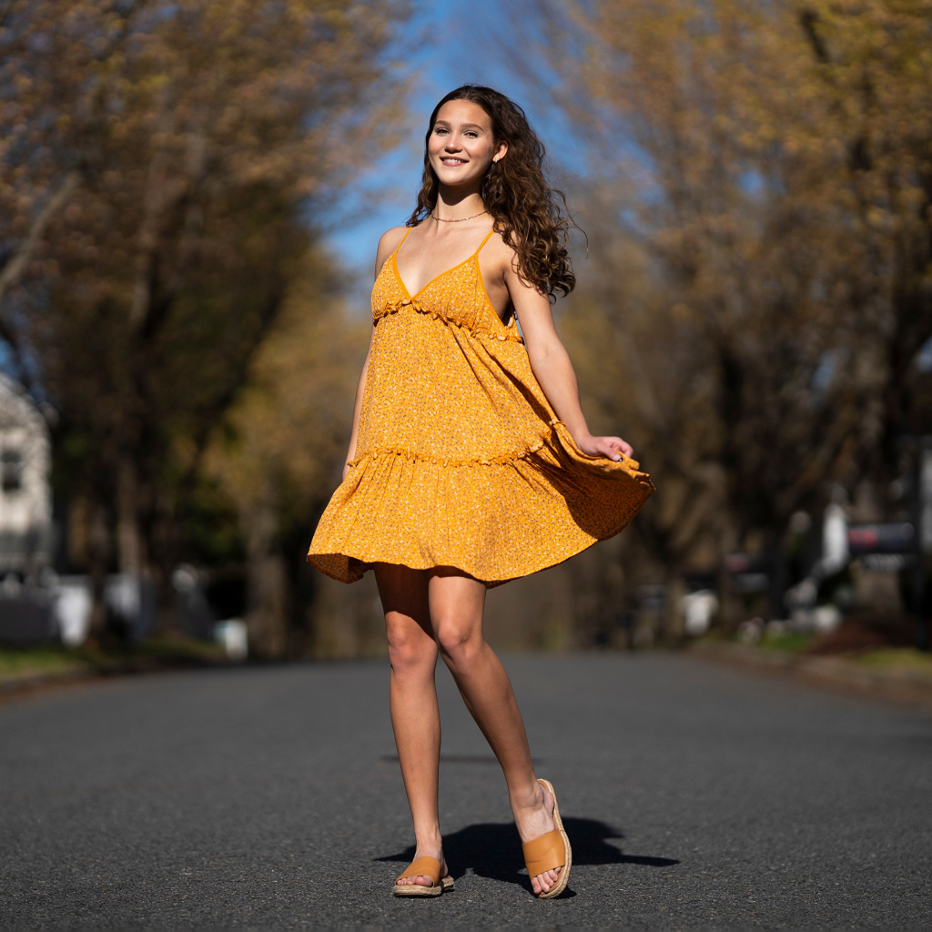 Молодая девушка в коротком платье на дороге  летом