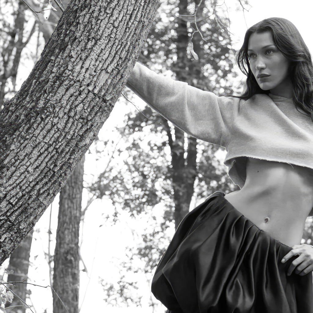 Модель Белла Хадид стоит у дерева в парке