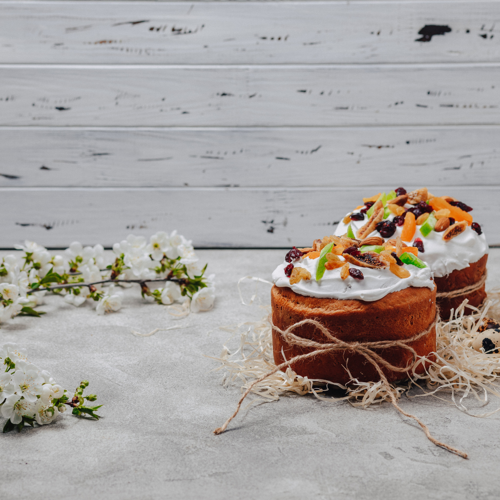 Красивые пасхальные куличи с веткой вишни на сером столе на Пасху