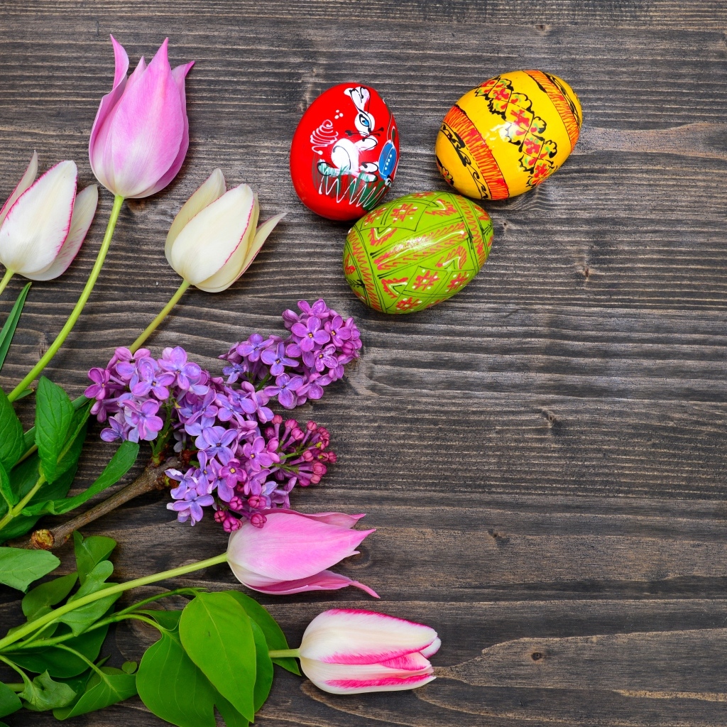 Пасхальные яйца с живыми цветами на столе 