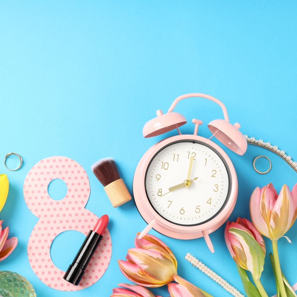 Будильник, цветы и декор на голубом фоне на 8 марта