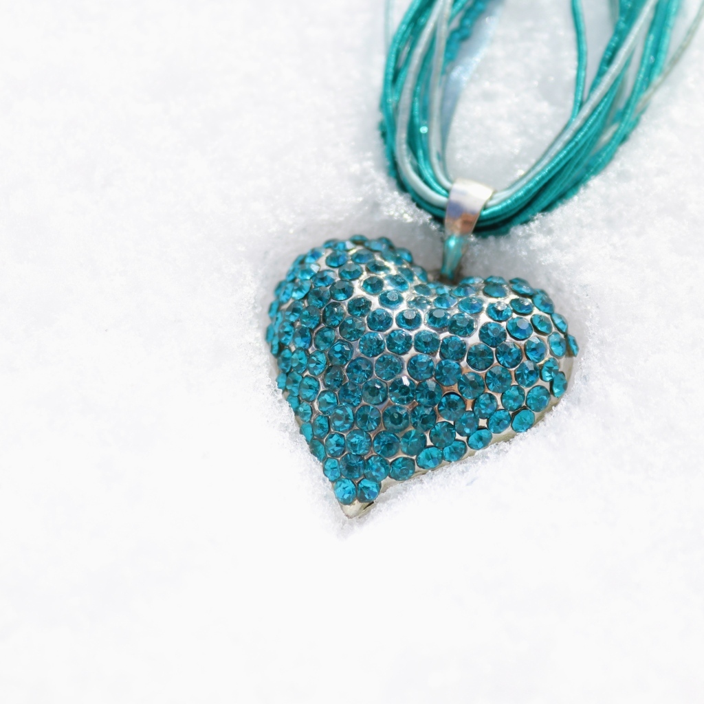 Голубой кулон в форме сердца на снегу