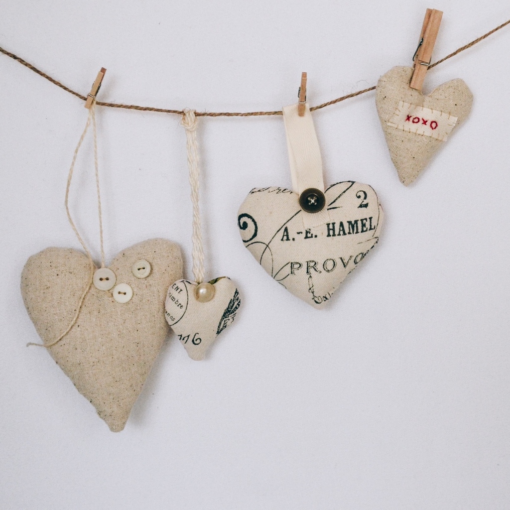 Сердечки из ткани на веревке на серой стене