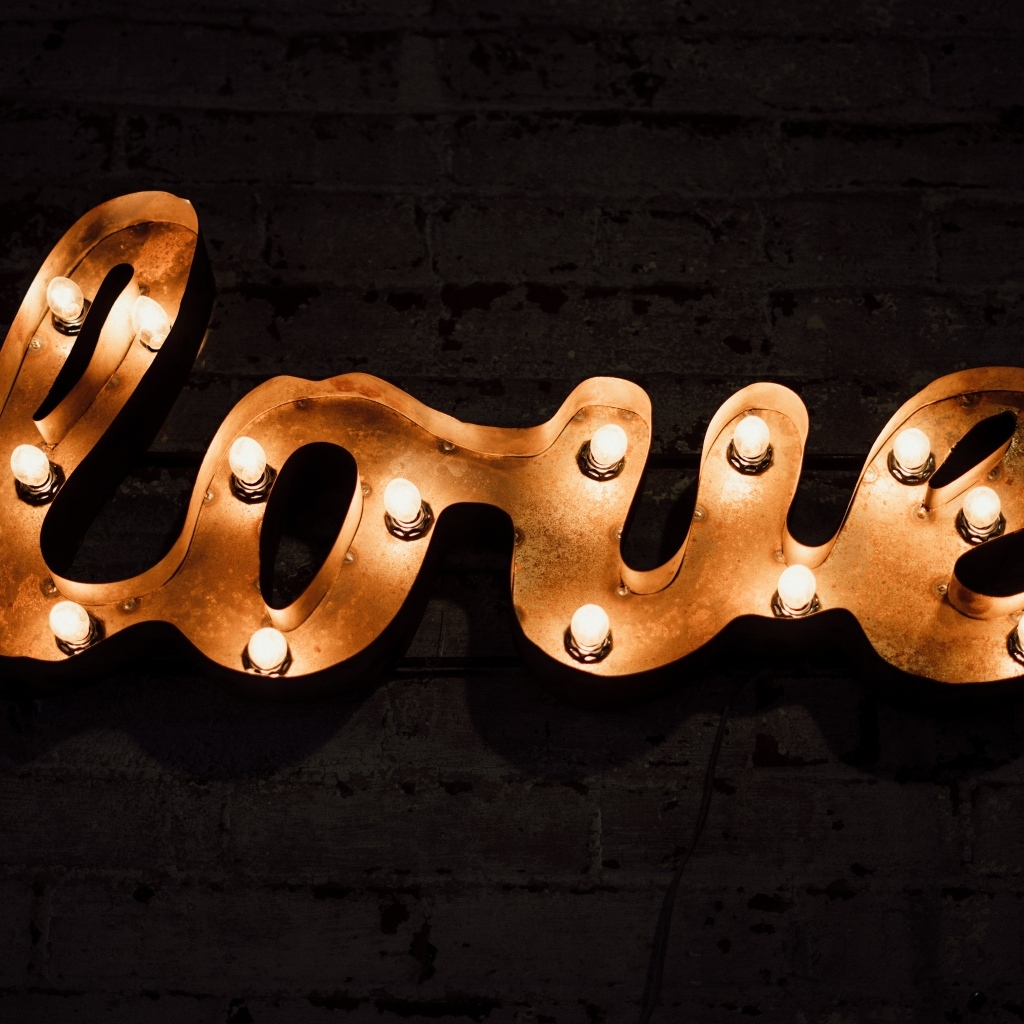 Светящаяся надпись любовь на черной стене