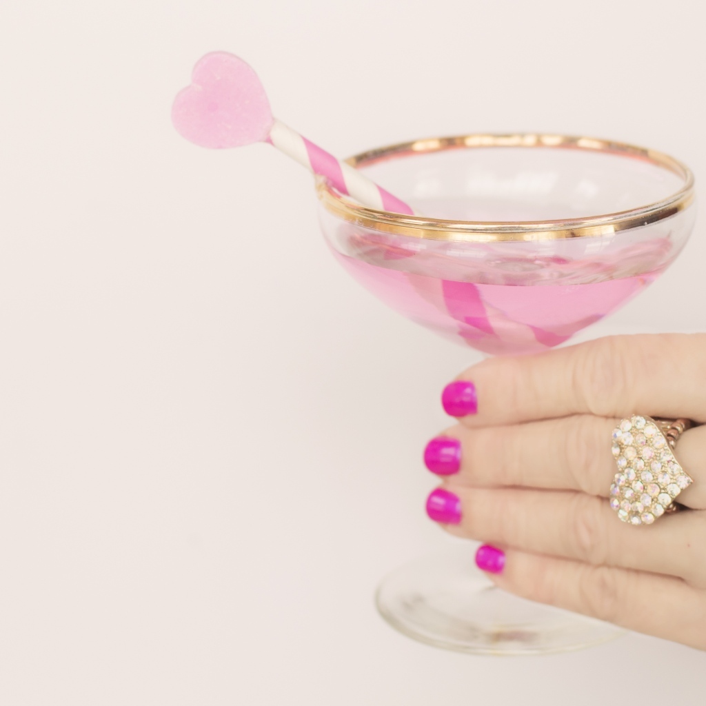 Кольцо в форме сердца на руке девушки с бокалом