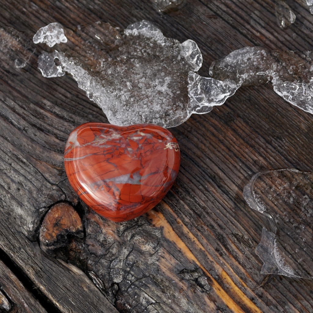 Сердце из камня на деревянной лавке с тающим снегом