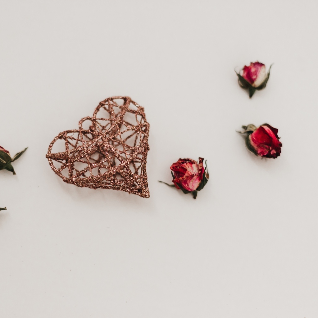 Плетеное сердце с сухими розами на сером фоне