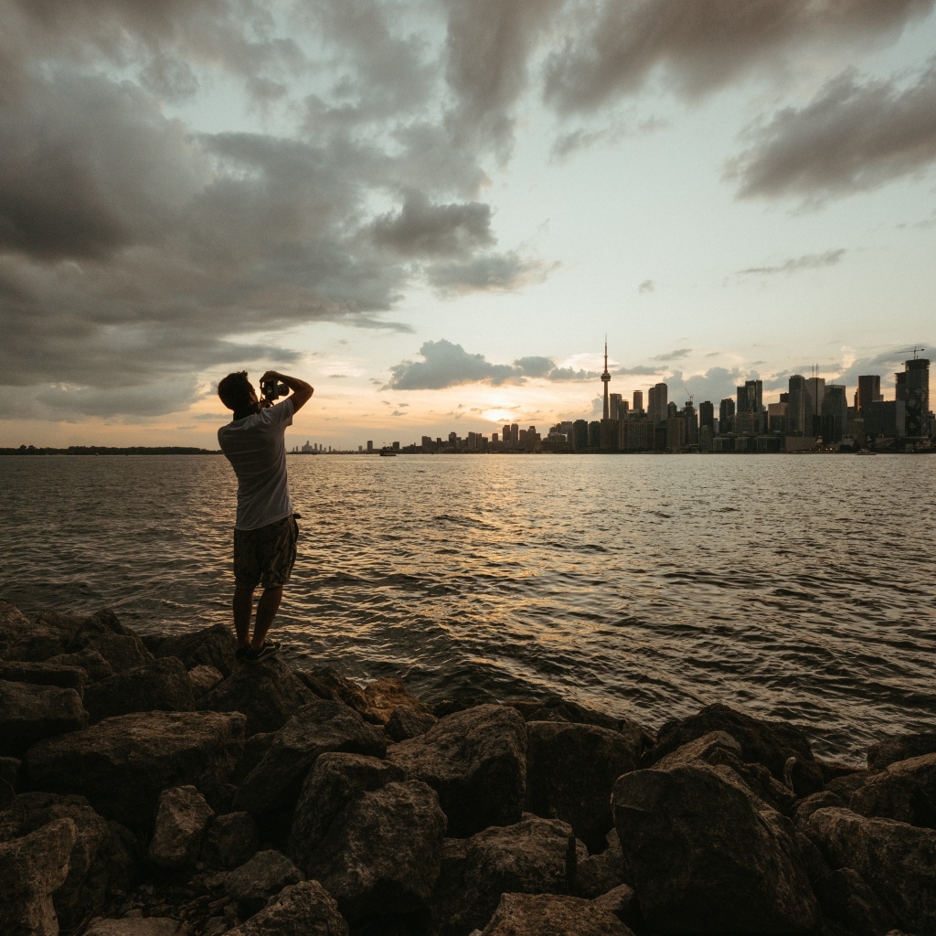 Мужчина делает фото города у моря