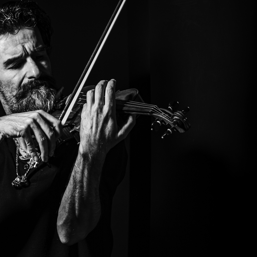 Мужчина музыкант со скрипкой в руках