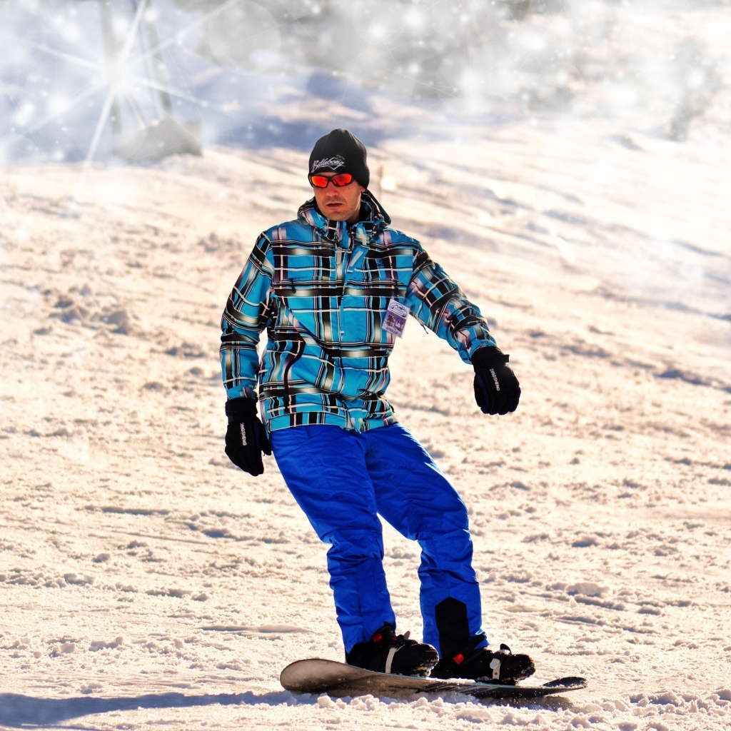Мужчина сноубордист спускается по склону