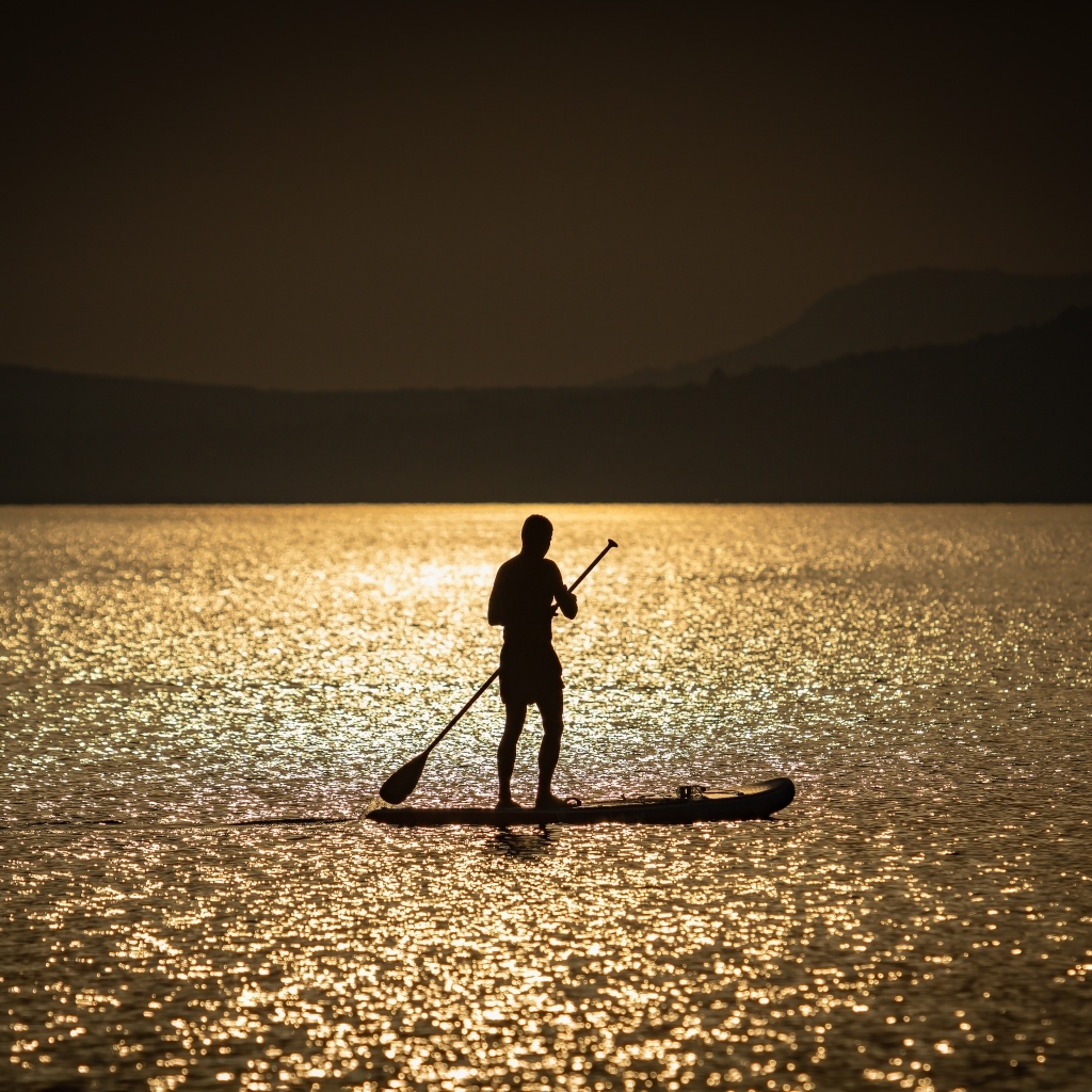 Мужчина серфингист в море на закате